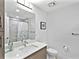 Bathroom with quartz countertop vanity, sleek fixtures, framed mirror and tiled shower at 1709 N Tamiami Trl # 318, Sarasota, FL 34234