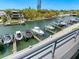 View of the boat dock with multiple boats, surrounded by trees and modern residences along the waterway at 1709 N Tamiami Trl # 318, Sarasota, FL 34234