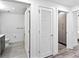 Hallway view showcasing a full bathroom, closet with louvered door, and additional storage space at 1709 N Tamiami Trl # 318, Sarasota, FL 34234