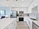 Modern white kitchen featuring stainless steel appliances and an island with quartz countertop at 1709 N Tamiami Trl # 318, Sarasota, FL 34234