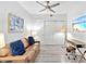 Living room featuring a ceiling fan, couch with decorative pillows, sliding closet doors, desk and modern decor at 1709 N Tamiami Trl # 318, Sarasota, FL 34234