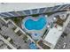 Aerial view of a kidney bean shaped pool, with surrounding lounge area and parking, located between modern apartment buildings at 1709 N Tamiami Trl # 318, Sarasota, FL 34234