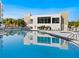 Large community pool with modern building featuring a gym visible through large windows, surrounded by patio furniture at 1709 N Tamiami Trl # 318, Sarasota, FL 34234