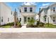 Charming two-story home featuring a quaint porch, green door, and lush landscaping at 172 Eagleston Ln, Sarasota, FL 34240