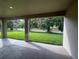 Covered patio overlooking a lush, well-maintained backyard with mature trees and a privacy fence at 19575 Fort King Run, Brooksville, FL 34601
