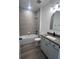 Modern bathroom features a tub with tiled shower, vanity with an arched mirror, and neutral color palette at 19575 Fort King Run, Brooksville, FL 34601