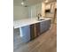 Kitchen island features white countertops, stainless steel dishwasher, and blue cabinetry at 19575 Fort King Run, Brooksville, FL 34601