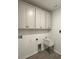 Bright laundry room with ample cabinet space and utility sink at 19575 Fort King Run, Brooksville, FL 34601