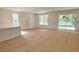 Bright, airy living area with large windows and a sliding glass door, awaiting flooring installation at 19575 Fort King Run, Brooksville, FL 34601