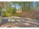 Backyard with brick floors, fence, greenery, and small metal fire pit with crushed gravel at 2072 Misty Sunrise Trl, Sarasota, FL 34240