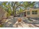 Inviting backyard patio with stylish outdoor seating, lush trees, and a tranquil fountain at 2072 Misty Sunrise Trl, Sarasota, FL 34240