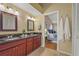 Bathroom featuring a dual sink vanity, wood cabinets, and access to the main bedroom at 2072 Misty Sunrise Trl, Sarasota, FL 34240