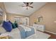 Bedroom with a ceiling fan, wood floors, white nightstand and doors leading to the outside at 2072 Misty Sunrise Trl, Sarasota, FL 34240