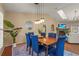 Stylish dining room featuring a wooden table, blue chairs, and modern light fixtures at 2072 Misty Sunrise Trl, Sarasota, FL 34240