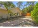 Exterior view of the back of the house with tropical landscaping and a wood fence at 2072 Misty Sunrise Trl, Sarasota, FL 34240