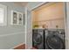 Laundry room with front-loading washer and dryer plus added storage shelves at 2072 Misty Sunrise Trl, Sarasota, FL 34240