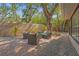 Back patio with brick floors, fence, lounge seating and lots of lush trees and greenery at 2072 Misty Sunrise Trl, Sarasota, FL 34240
