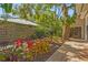 The side yard features lush tropical landscaping, brick pavers, and a wood fence at 2072 Misty Sunrise Trl, Sarasota, FL 34240