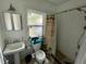 Bathroom with a pedestal sink, toilet, and a shower with a tropical-themed curtain at 2120 8Th W Ave, Bradenton, FL 34205