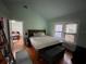Light-filled bedroom featuring hardwood floors, two windows, a door, and a comfortable king-size bed at 2120 8Th W Ave, Bradenton, FL 34205