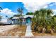 Exterior view of a quaint blue home featuring a striking turquoise door and well-kept walkway at 2120 8Th W Ave, Bradenton, FL 34205
