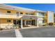 The front of a two-story yellow building with a covered entrance at 2155, under a clear blue sky at 2155 Wood St # B18, Sarasota, FL 34237