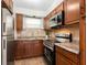 A cozy kitchen with wood cabinets, stainless steel appliances, and stone-look countertops at 2155 Wood St # B18, Sarasota, FL 34237