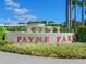 The beige Payne Park sign with red letters is surrounded by manicured shrubbery and clear blue skies at 2155 Wood St # B18, Sarasota, FL 34237