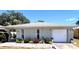 Charming single-story home featuring a one-car garage and a beautifully landscaped front yard with colorful flowers at 240 Patterson Ave, Osprey, FL 34229