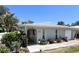 Delightful home exterior with a manicured garden, featuring flowering shrubs and a stepping stone walkway to the entryway at 240 Patterson Ave, Osprey, FL 34229