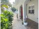 Charming front porch with plants, white gravel, and a red door, creating an inviting entrance at 240 Patterson Ave, Osprey, FL 34229