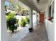 Inviting covered porch with tiled flooring, decorative plants, and a bright orange front door, offering a warm welcome at 240 Patterson Ave, Osprey, FL 34229