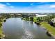 Aerial view of a serene lake surrounded by lush landscaping and upscale homes at 26725 Raphis Royale Blvd, Englewood, FL 34223