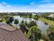 Aerial view showcasing the serene lake and beautiful landscaping surrounding the property at 26725 Raphis Royale Blvd, Englewood, FL 34223