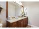 Bathroom featuring a granite countertop, wood cabinets, and a large mirror at 26725 Raphis Royale Blvd, Englewood, FL 34223