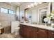 Elegant bathroom featuring a walk-in shower, granite countertops, and wood cabinets at 26725 Raphis Royale Blvd, Englewood, FL 34223