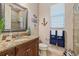 Inviting bathroom with a granite countertop, wood cabinets, and nautical themed decor at 26725 Raphis Royale Blvd, Englewood, FL 34223