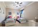 Comfortable bedroom features two twin beds with coastal-themed bedding, a ceiling fan, and serene lighting at 26725 Raphis Royale Blvd, Englewood, FL 34223