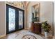Elegant foyer with intricate tile flooring, decorative entry doors, and stylish console table with mirror at 26725 Raphis Royale Blvd, Englewood, FL 34223
