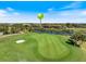 An immaculate golf course with manicured greens, a pristine sand bunker, and a serene lake backdrop at 26725 Raphis Royale Blvd, Englewood, FL 34223