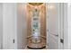 The hallway has decorative tile flooring, neutral walls, and a view of the living room at 26725 Raphis Royale Blvd, Englewood, FL 34223