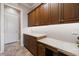 Well-organized laundry room with granite countertops, wooden cabinets, and ample storage space at 26725 Raphis Royale Blvd, Englewood, FL 34223