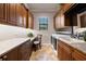 Well-organized laundry room featuring granite countertops, wooden cabinets, a utility sink, and modern washer and dryer at 26725 Raphis Royale Blvd, Englewood, FL 34223