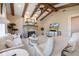 Inviting living room with vaulted ceilings, wood beams, stone fireplace, and comfortable neutral-toned furniture at 26725 Raphis Royale Blvd, Englewood, FL 34223