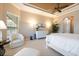 The main bedroom has a comfy chair, a tv, and a trey ceiling with a ceiling fan at 26725 Raphis Royale Blvd, Englewood, FL 34223