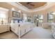 This main bedroom has neutral walls, tray ceiling, and windows with views of the backyard at 26725 Raphis Royale Blvd, Englewood, FL 34223