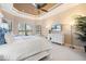 Relax in this main bedroom with a trey ceiling, large windows, and a television for late-night enjoyment at 26725 Raphis Royale Blvd, Englewood, FL 34223