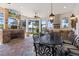 The screened-in patio has an outdoor kitchen, stone fireplace, and a dining table with lake views at 26725 Raphis Royale Blvd, Englewood, FL 34223