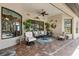The outdoor patio space has brick floors, comfortable seating, a ceiling fan, and access to the pool at 26725 Raphis Royale Blvd, Englewood, FL 34223