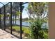 The lanai is screened in with views of a pond and mature trees at 26725 Raphis Royale Blvd, Englewood, FL 34223